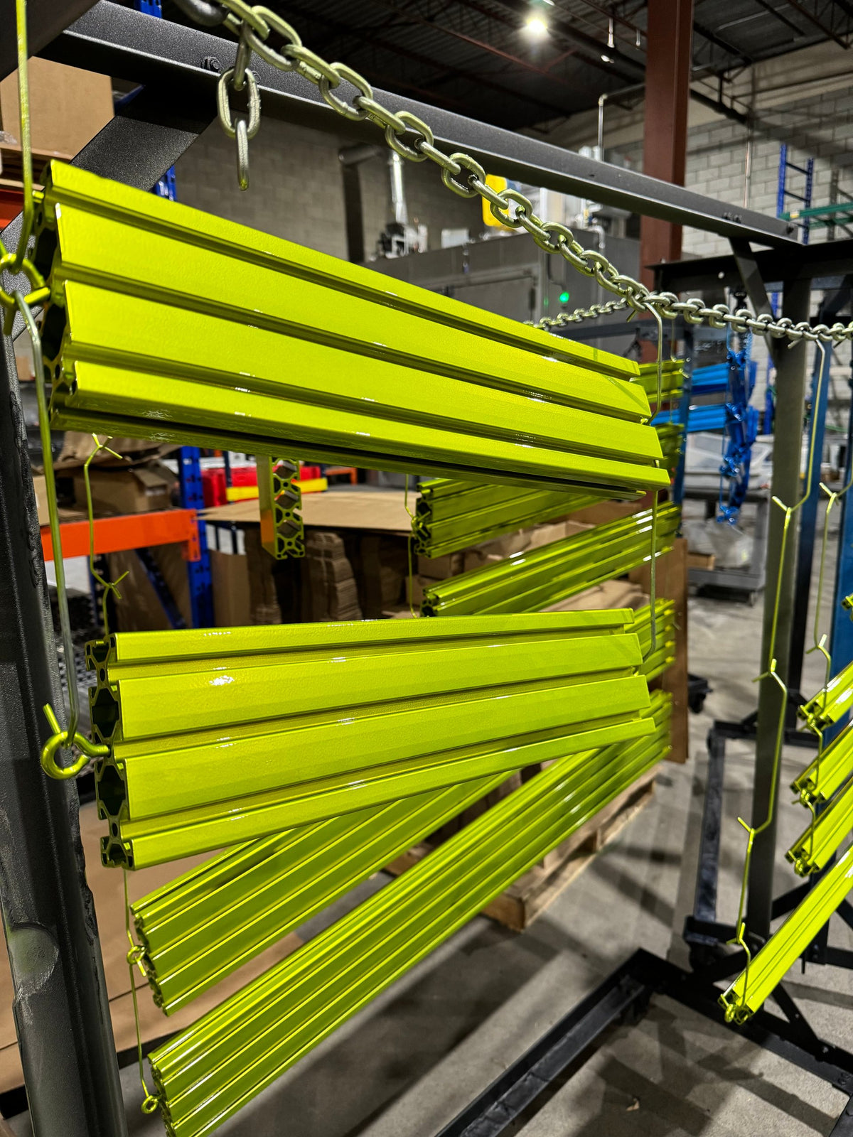 Rack loaded with aluminum extrusions powder coated in lime green