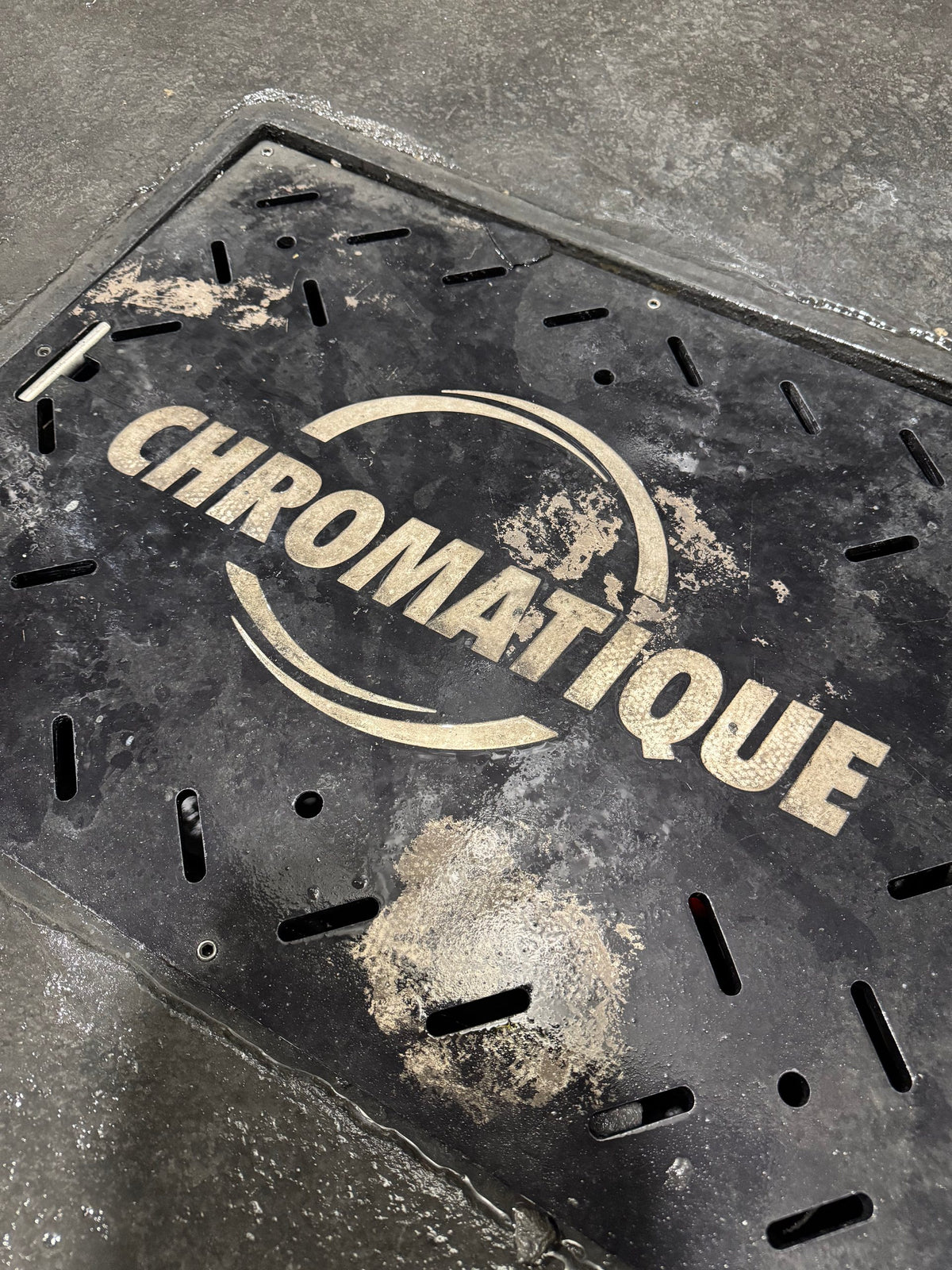 Laser-cut steel plate with the Chromatique logo