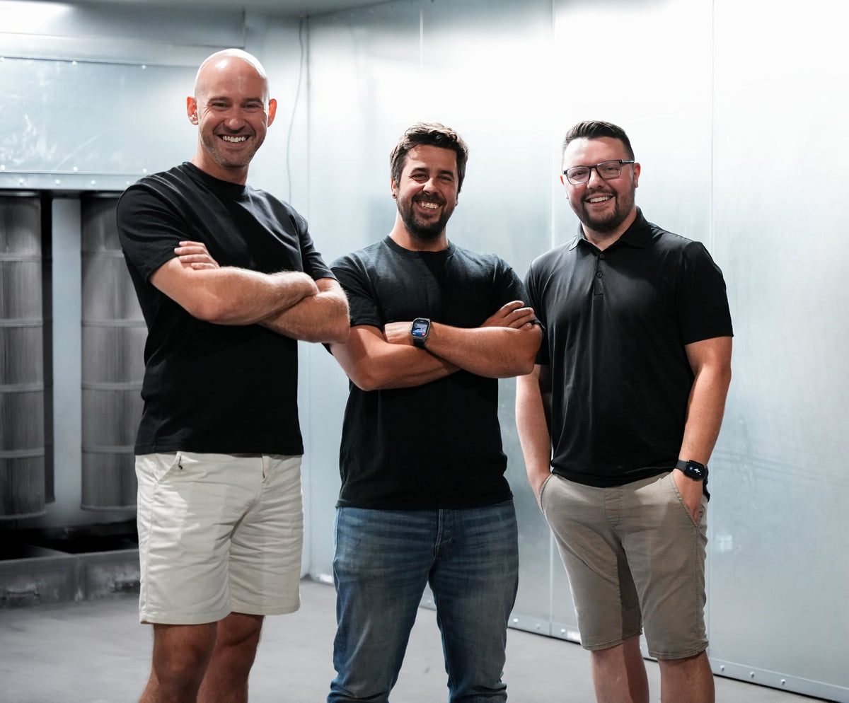 Three members of the Chromatique team standing in the paint booth