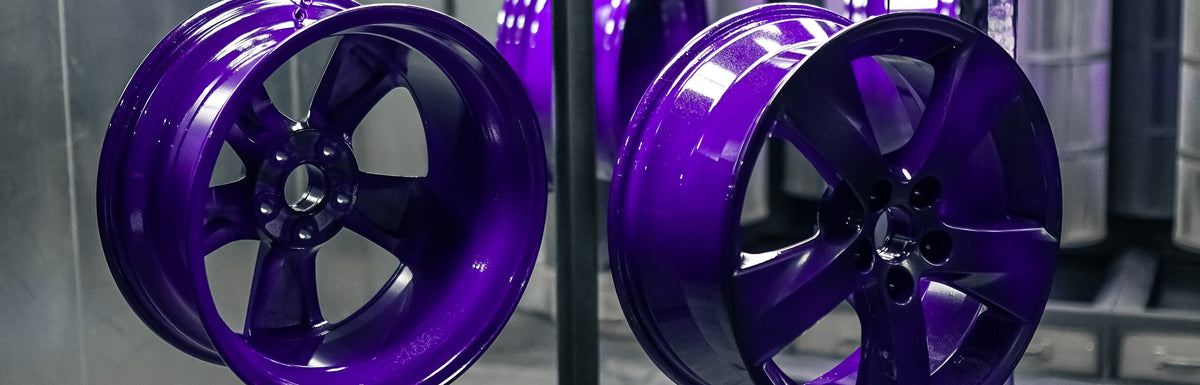 Two wheels powder coated in gloss purple hanging side by side