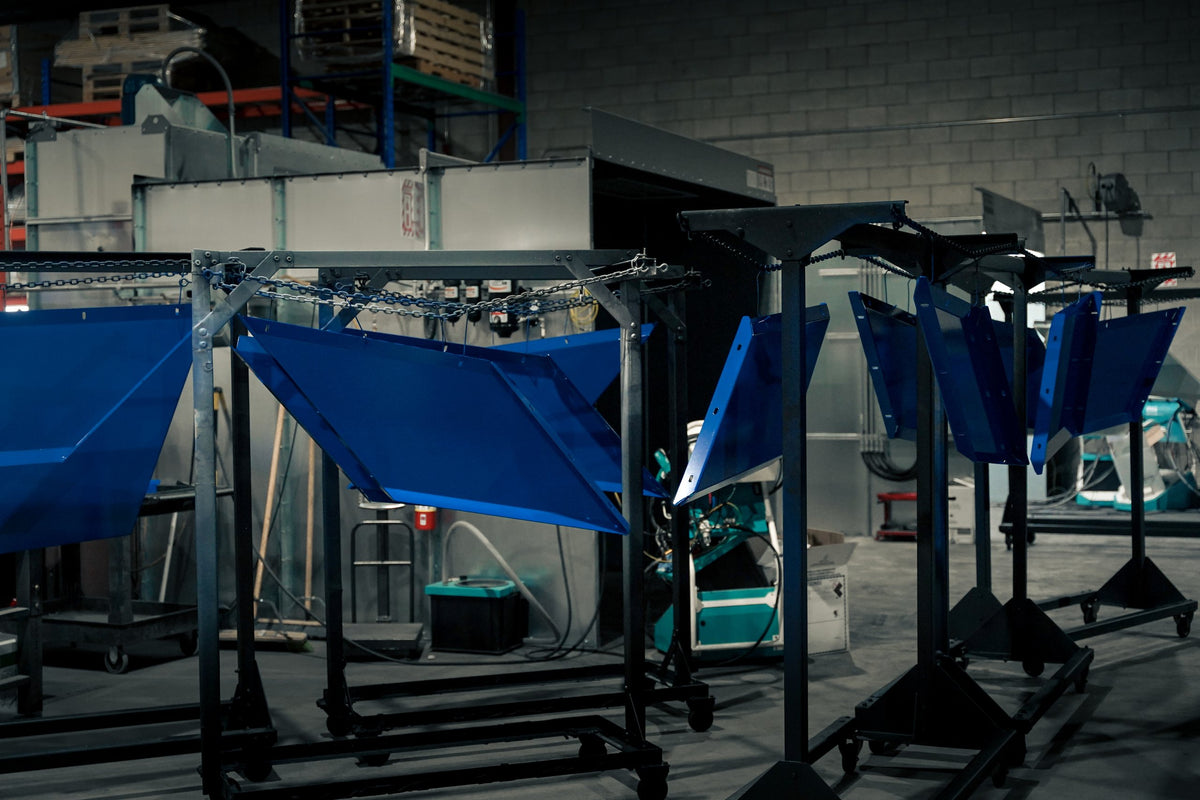 Steel panels powder coated in blue on rolling racks