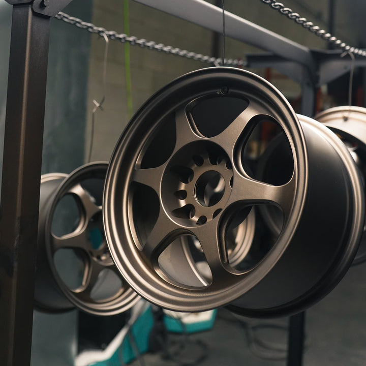 Wheels powder coated in matte bronze hanging in the shop