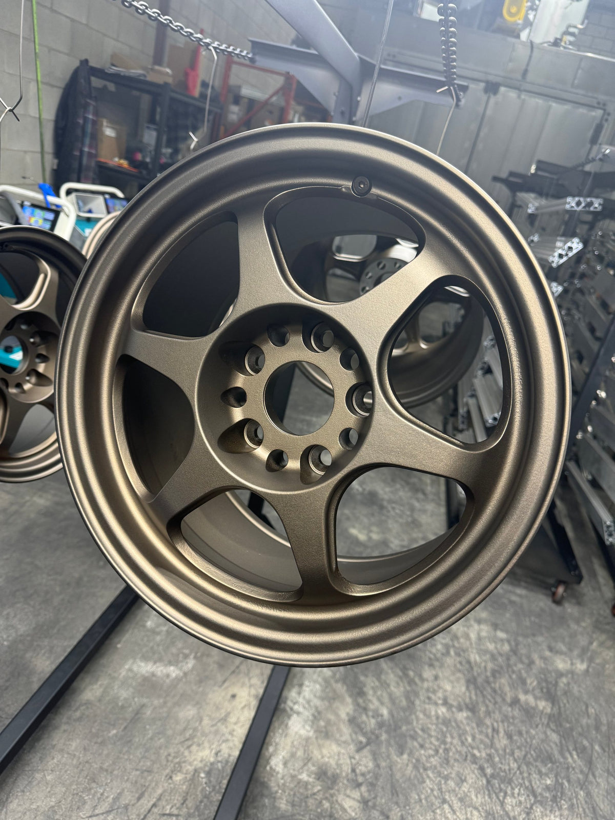 Wheel powder coated in matte bronze hanging in the shop