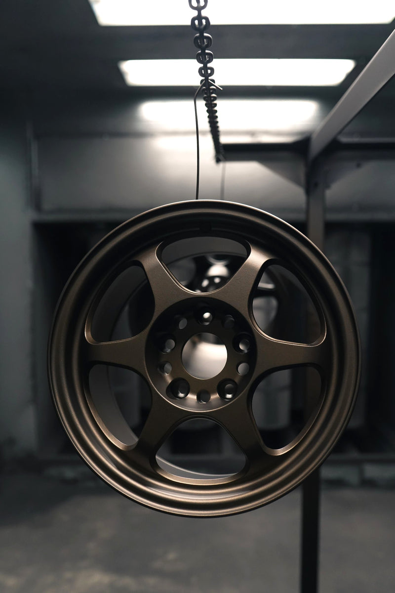 Wheel powder coated in matte bronze hanging in the booth at the Chromatique shop in Anjou