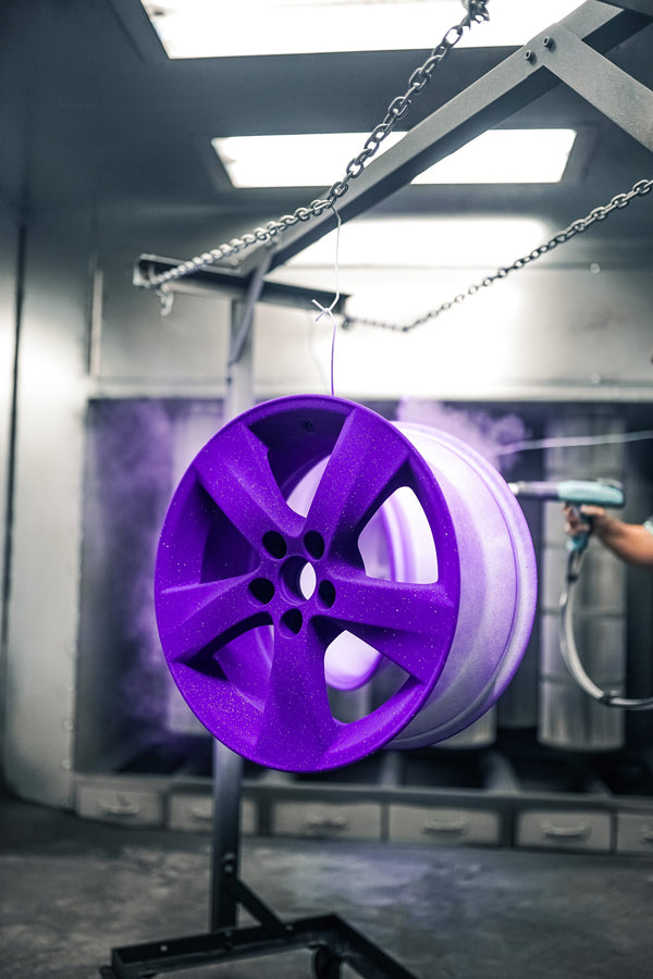 Purple powder-coated wheel in the spray booth